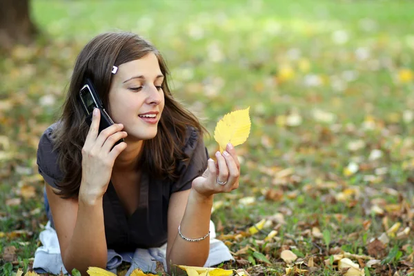 Femme appelant par téléphone dans le parc d'automne — Photo