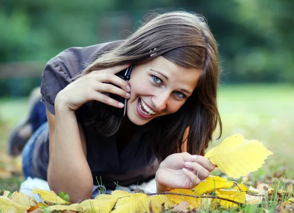 Γυναίκα καλώντας τηλεφωνικά στο πάρκο φθινόπωρο — Φωτογραφία Αρχείου