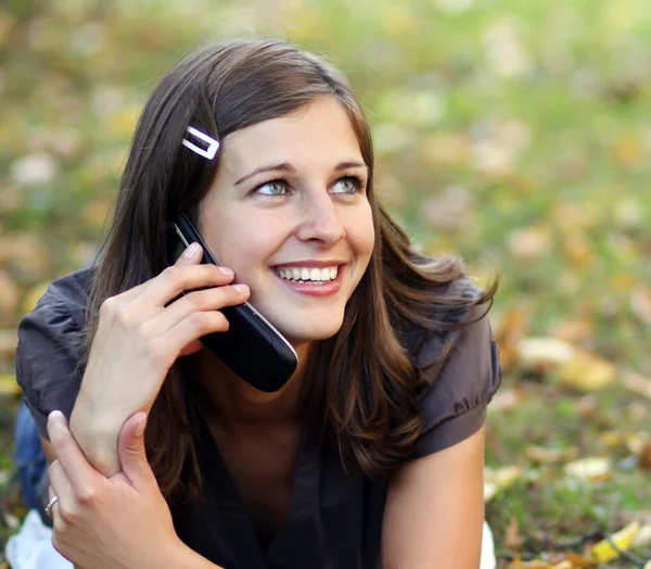 Γυναίκα καλώντας τηλεφωνικά στο πάρκο φθινόπωρο — Stockfoto