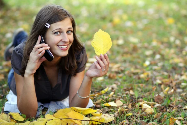 Femme appelant par téléphone dans le parc d'automne — Photo