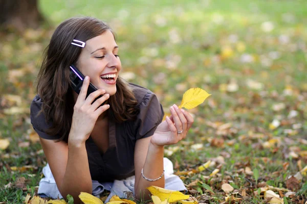 Donna che chiama per telefono nel parco autunnale — Foto Stock