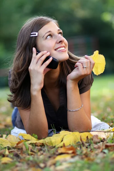 Mulher chamando por telefone no parque de outono — Fotografia de Stock