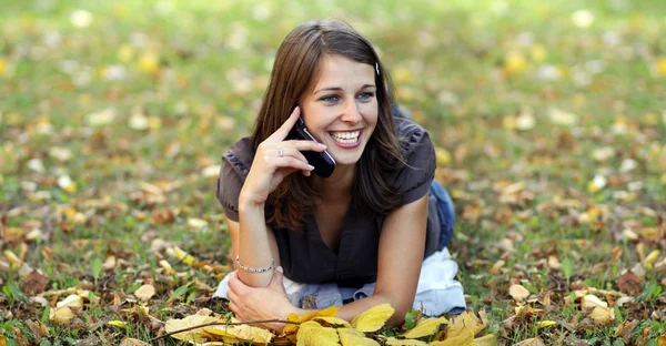 Γυναίκα καλώντας τηλεφωνικά στο πάρκο φθινόπωρο — Φωτογραφία Αρχείου