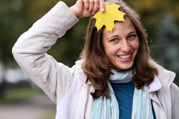 Schöne Frau mit einem Strauß Ahornblättern — Stockfoto