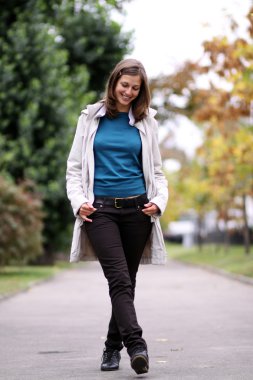 kadın sonbahar parkta yürüyüş, tam boy