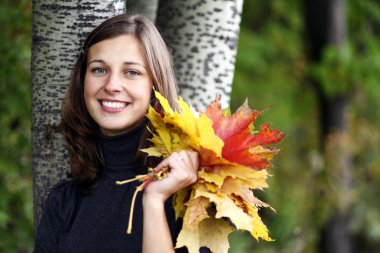 güzel bir kadın bir buket akçaağaç yaprakları