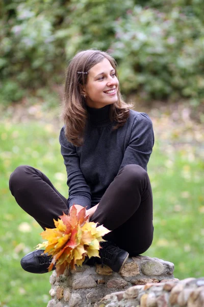 Belle femme avec un bouquet de feuilles d'érable — Photo