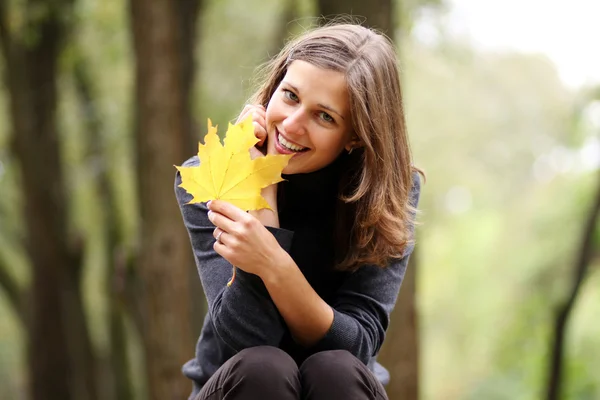 Schöne Frau mit einem Strauß Ahornblättern — Stockfoto