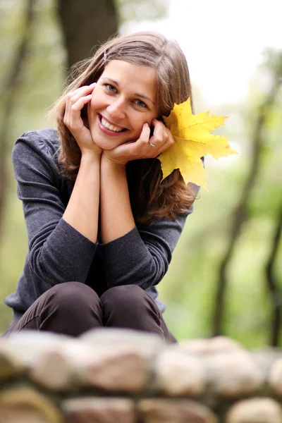 Schöne Frau mit einem Strauß Ahornblättern — Stockfoto