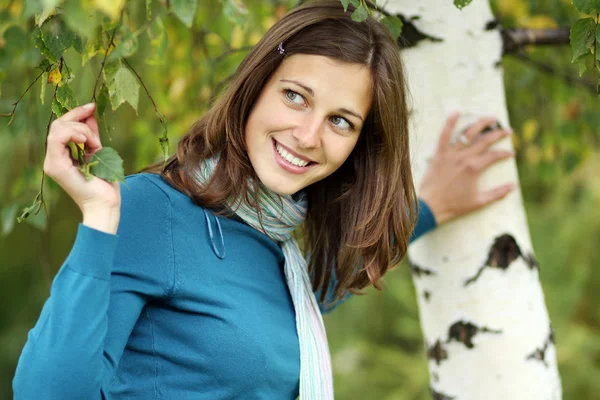 Glückliche junge Frau an einer weißen Birke — Stockfoto