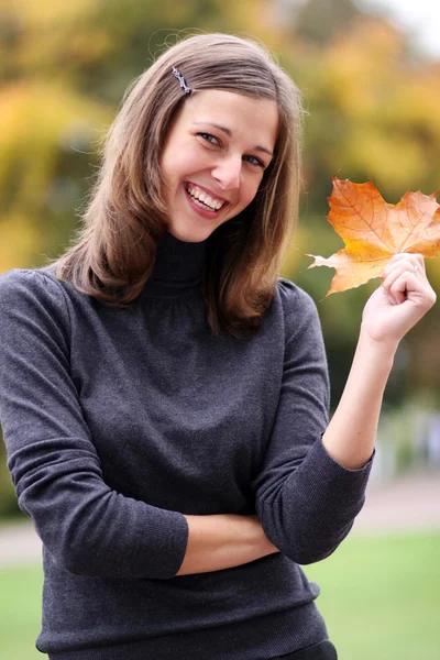 Mooie vrouw met een boeket van esdoorn bladeren — Stockfoto