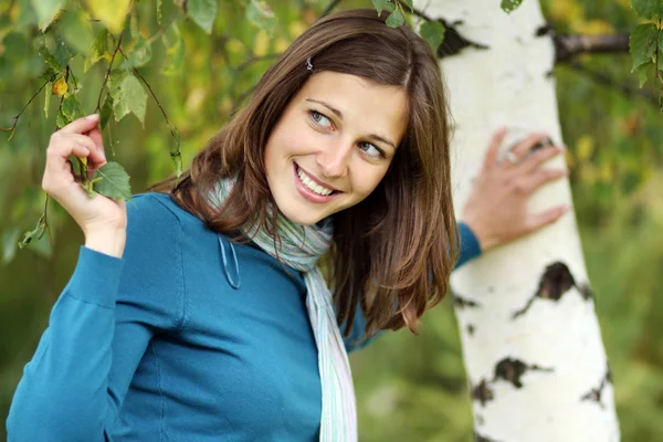 Glückliche junge Frau an einer weißen Birke — Stockfoto