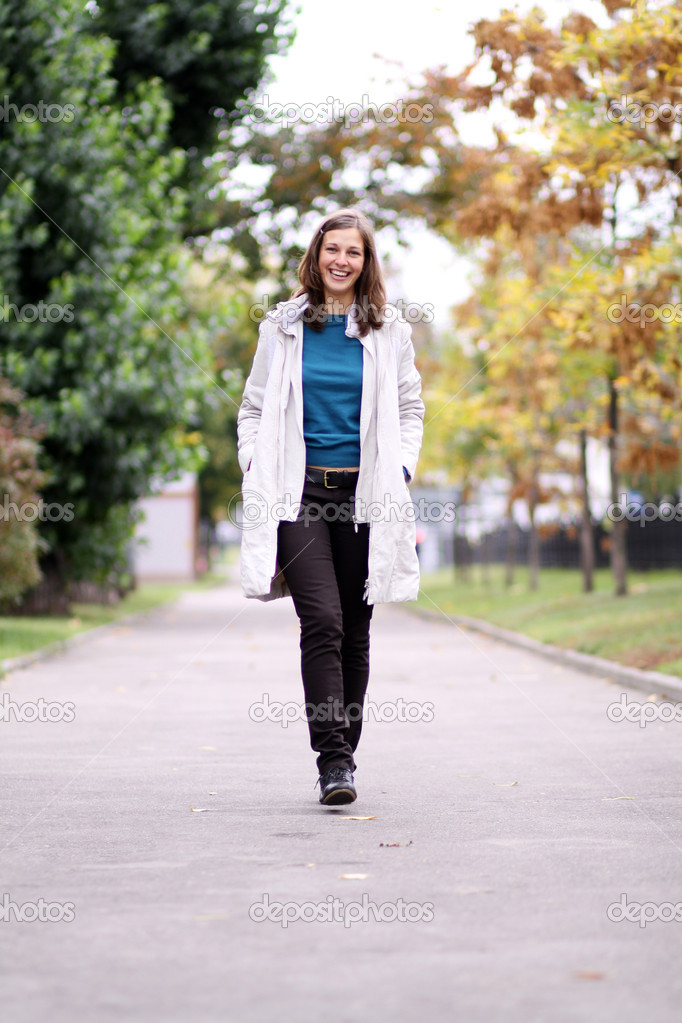 Full length, walking woman in autumn park