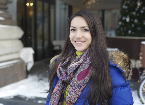 Portret van een jonge vrouw op de achtergrond van een winter stad — Stockfoto