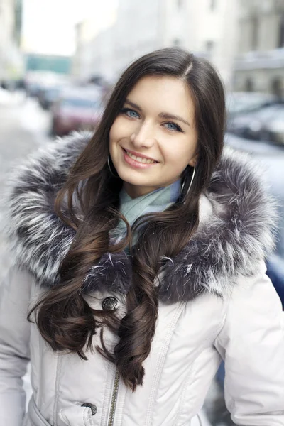 Young woman walking down snow covered street — Stock Photo, Image