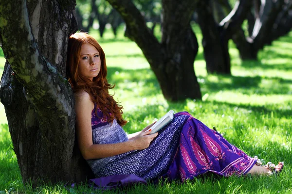 Mujer joven en verano, libro de lectura del parque verde — Foto de Stock
