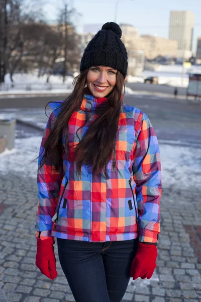 Portret van een jonge vrouw op de achtergrond van een winter stad — Stockfoto