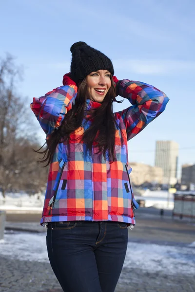 Retrato de uma jovem no fundo de uma cidade de inverno — Fotografia de Stock