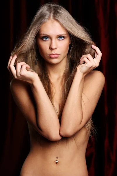 Sexy naked young woman in dark studio — Stock Photo, Image