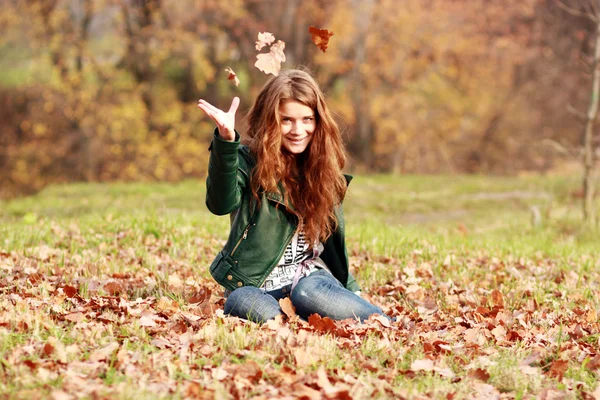 Retrato de una mujer feliz contra hojas amarillas — Foto de Stock