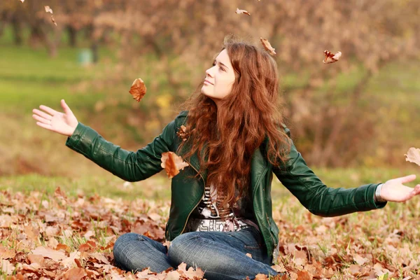 Portrait of a happy woman against yellow leaves — Stock Photo, Image