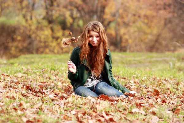 Portræt af en glad kvinde mod gule blade - Stock-foto