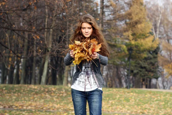 Retrato de una mujer feliz contra hojas amarillas —  Fotos de Stock