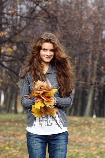 Портрет счастливой женщины против жёлтых листьев — стоковое фото