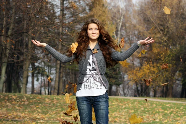 Retrato de una mujer feliz contra hojas amarillas —  Fotos de Stock