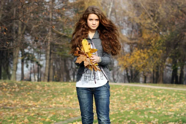 Portrait d'une femme heureuse contre les feuilles jaunes — Photo