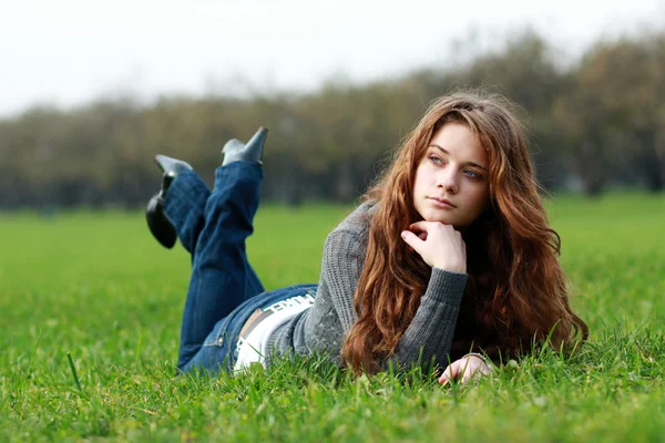 Frau liegt auf Laubteppich im Herbstpark — Stockfoto