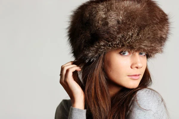 Ung kvinna i en furry hatt — Stockfoto