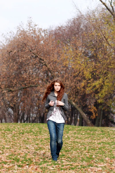 Femme à pied dans le parc d'automne — Photo