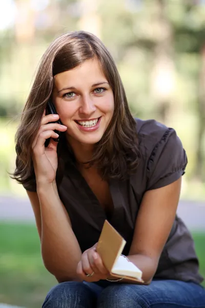 Happy young woman calling by phone — Stock Photo, Image