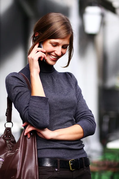 Ung glad kvinna ringer via telefon på gatan — Stockfoto