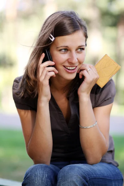 Mutlu genç bir kadın telefon ederken — Stok fotoğraf