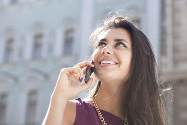 mutlu kadın sokakta telefonla arıyor