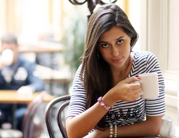 Beautiful young girl sipping coffee — Stock Photo, Image