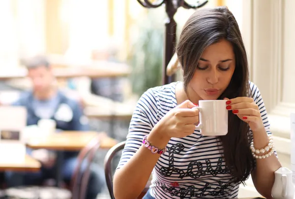 コーヒーをすすりながら美しい若い女の子 — ストック写真