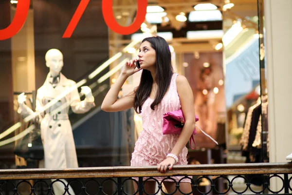 Mujer joven en las llamadas de tienda por teléfono —  Fotos de Stock