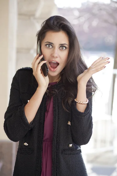 Ung glad kvinna ringer via telefon på gatan — Stockfoto