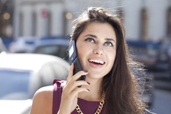 Ung glad kvinna ringer via telefon på gatan — Stockfoto