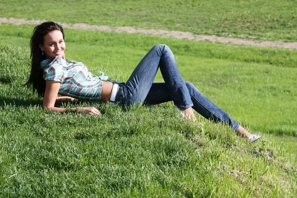 Retrato de una joven tumbada en un césped verde —  Fotos de Stock