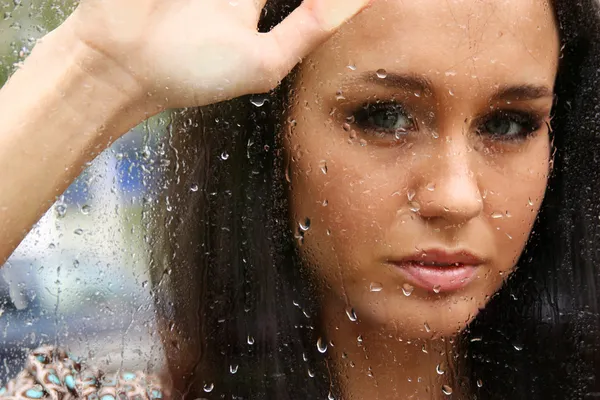 Portret młodej kobiety w pobliżu okna po deszczu — Zdjęcie stockowe