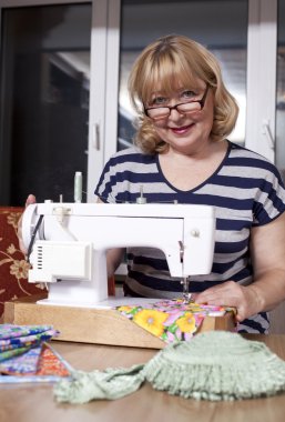 yaşlı kadın dikiş makinesinde diker