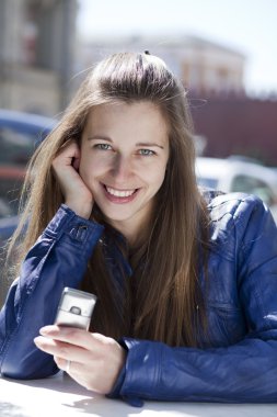 Genç bayan telefonda bir mesaj okuyor.