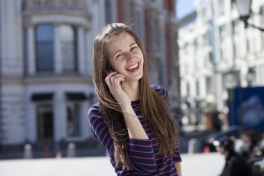 mutlu kadın sokakta telefonla arıyor