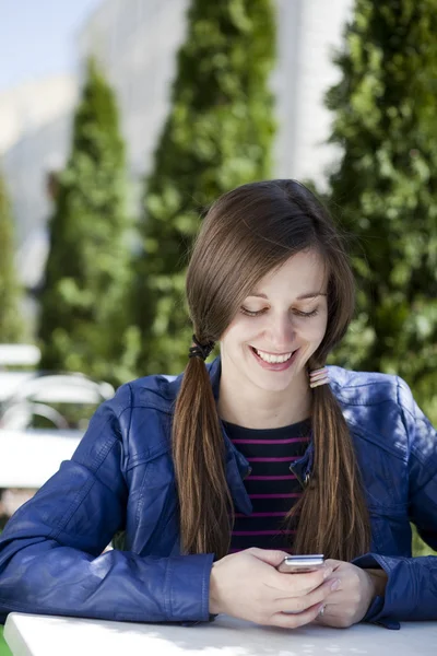 Jeune femme lisant un message au téléphone — Photo