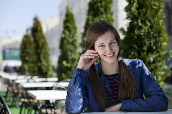 Gelukkig jongedame vragen per telefoon op straat — Stockfoto