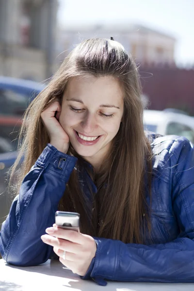 Ung kvinna läser ett meddelande på telefon — Stockfoto